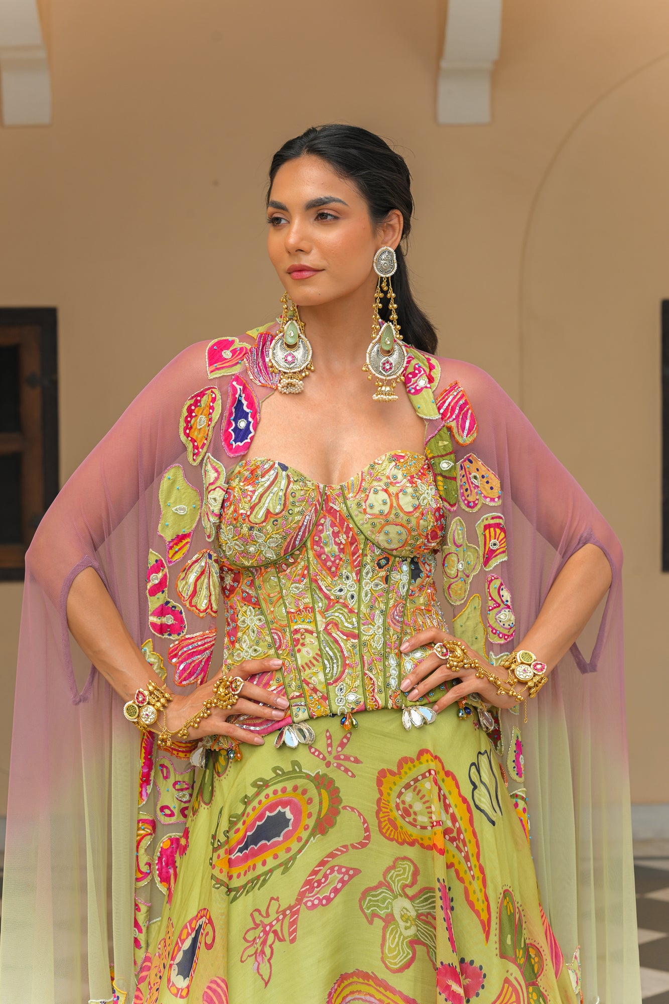 OLIVE BLOOM PRINTED LEHENGA AND EMBROIDERED. MIRROR CORSET AND APPLIQUÉ DUAL CAPE HIGHLIGHT