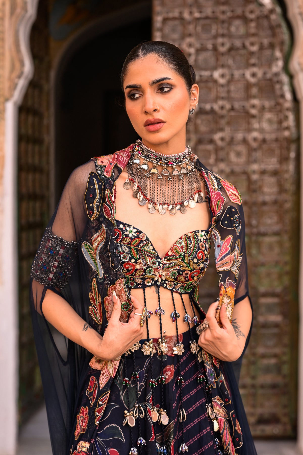 DUEL PRINTED LEHANGA WITH EMB TASSLE BLOUSE WITH APLIQUE CAPE