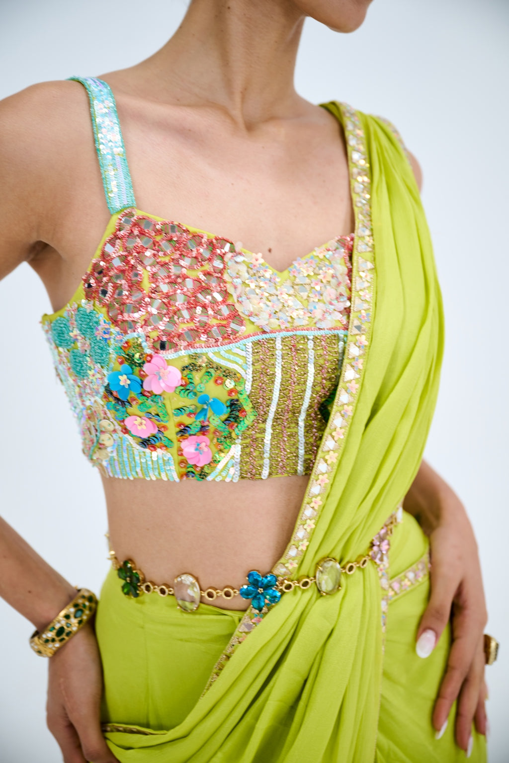 LIGHT GREEN PRE DRAPED SAREE PAIRED WITH EMBROIDERED CORSET AND EMEBELISHED BELT